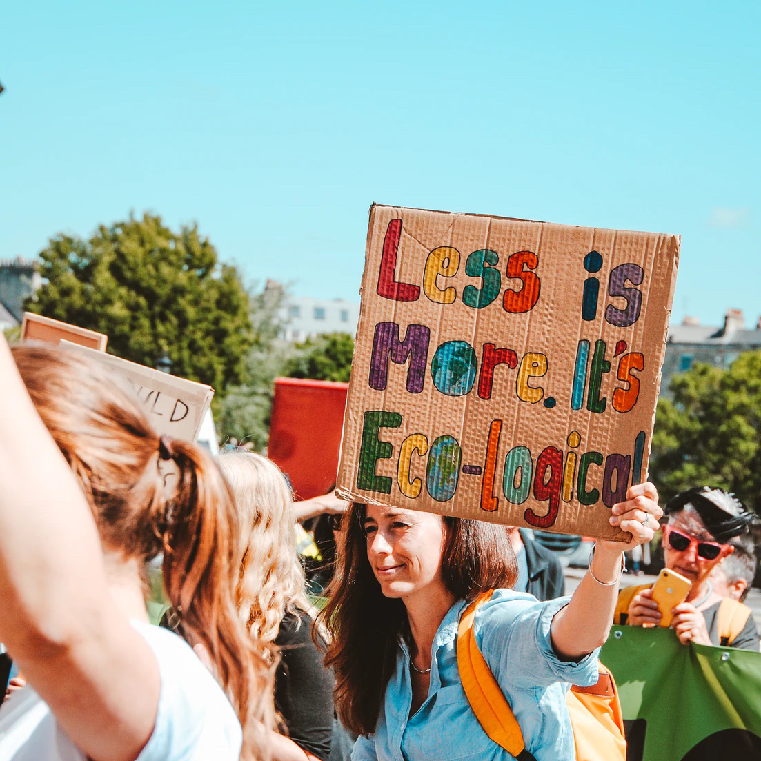 Frau auf Demo hält Plakat hoch